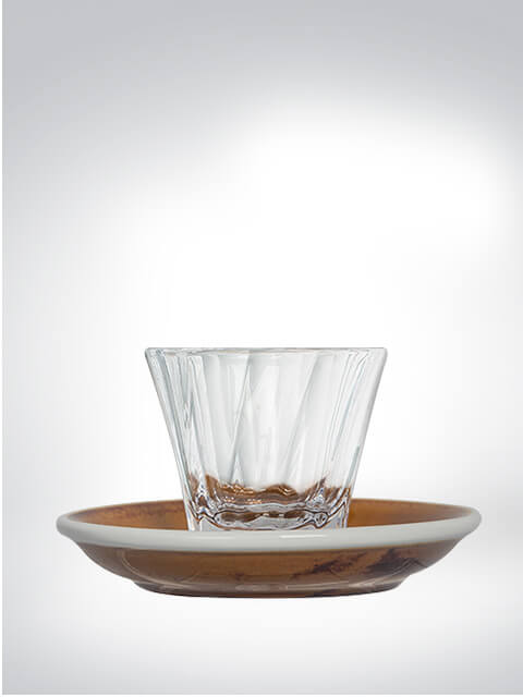 Glass with modern design on a wooden plate