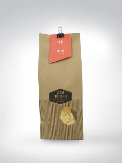 Verpackung mit Kaffeebohnen der Stadt Rösterei, braunes Design mit rotem Etikett