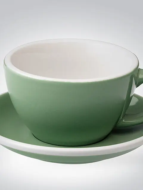 Elegante grüne Teetasse mit passender Untertasse auf weißem Hintergrund